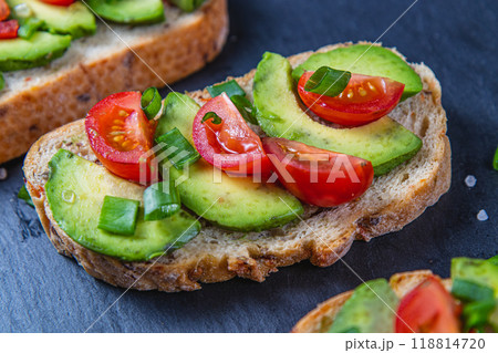 Avocado toast topped with tomato and green onion on a slice of carrot bread 118814720