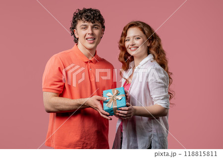 Young woman and man with gift box. Surprise, unexpected present. Birthday, celebration, surprise, anniversary concept. 118815811