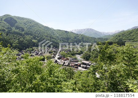 小高い丘の上から見た白川郷 雪渓が残る山並みと白川街道 合掌造りの古民家集落を望む 118817554