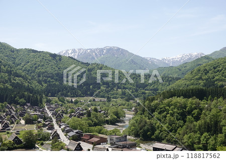 小高い丘の上から見た白川郷 雪渓が残る山並みと白川街道 合掌造りの古民家集落を望む 118817562