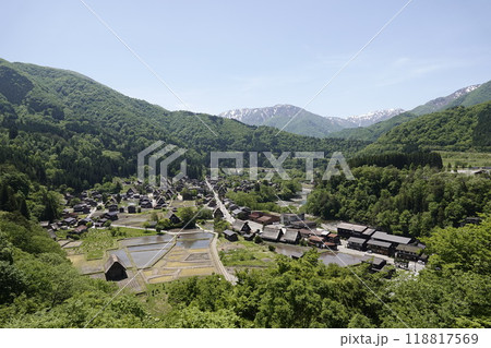 小高い丘の上から見た白川郷 雪渓が残る山並みと白川街道 合掌造りの古民家集落を望む 118817569