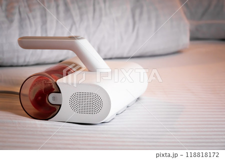 Specialized vacuum cleaner for removing linen mites and disinfecting bed linen and bedding. Vacuum cleaner with UV lamp on the bed Specialized vacuum cleaner for removing linen mites and disinfecting bed linen and bedding. Vacuum cleaner with UV lamp on the bed 118818172