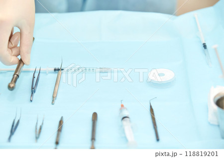 Sterile medical instruments and syringe on surgical tray in hospital setting 118819201