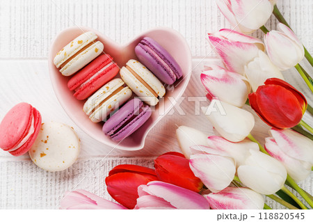 Pastel colorful tulips and vibrant macaroons fill a heart-shaped bowl Pastel colorful tulips and vibrant macaroons fill a heart-shaped bowl 118820545