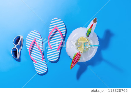 A vibrant summer vacation scene with flip flops, and a floating flamingo 118820763
