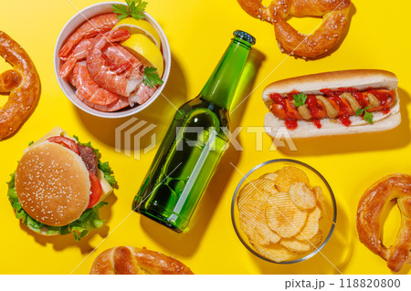 A vibrant photo showcasing a bottle of beer surrounded by various snacks and fast food A vibrant photo showcasing a bottle of beer surrounded by various snacks and fast food 118820800