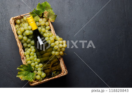 A wine bottle lies elegantly over a bed of fresh grapes 118820843