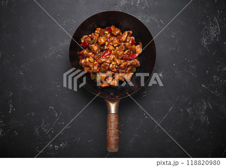 Traditional Chinese dish kung pao chicken in wok pan on dark background top view 118820980
