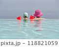 A young child with colorful floaties and a woman looking away from edge of infinity pool A young child with colorful floaties and a woman looking away from edge of infinity pool 118821059