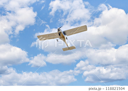 Single engine ultralight plane flying in the blue sky with white clouds 118821504