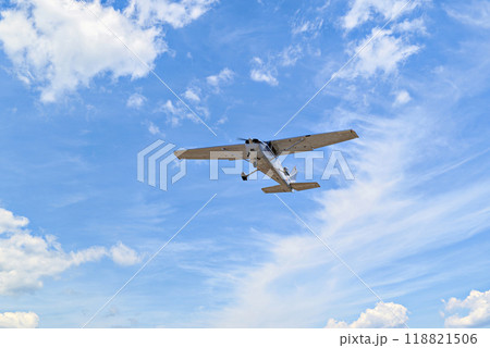 Single engine ultralight plane flying in the blue sky with white clouds 118821506