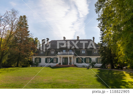 Historic Manor House with Green Lawn and Surrounding Trees 118822905