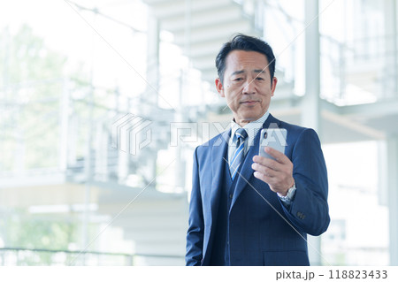 空港でスマートフォンを使う中高年のビジネスマン 118823433