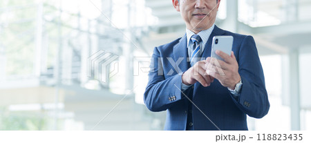 空港でスマートフォンを使う中高年のビジネスマン 118823435