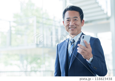 空港でスマートフォンを使う中高年のビジネスマン 118823438