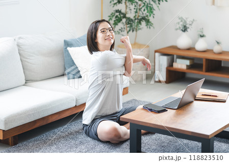 自宅のリビングでストレッチをする女性 自宅のリビングでストレッチをする女性 118823510