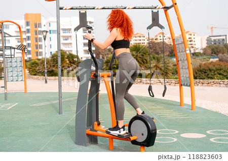 Sporty woman exercising on stepper machine at 118823603
