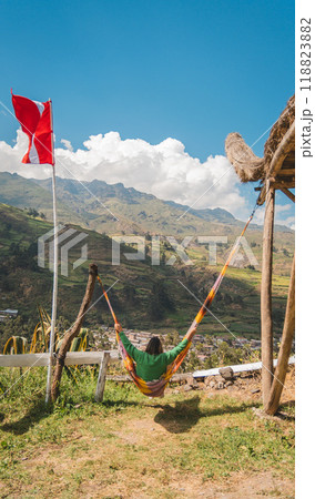 A person is hanging from a hammock in a grassy field, A Woman traveling through the peruvian andes. Canta, Lima, Peru. A person is hanging from a hammock in a grassy field, A Woman traveling through the peruvian andes. Canta, Lima, Peru. 118823882