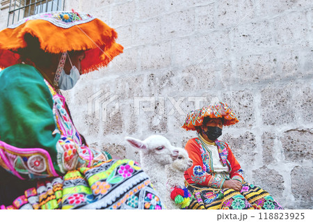 Peruvian woman in traditional clothes holding a baby llama in street, Arequipa, Peru. Selective Focus 118823925