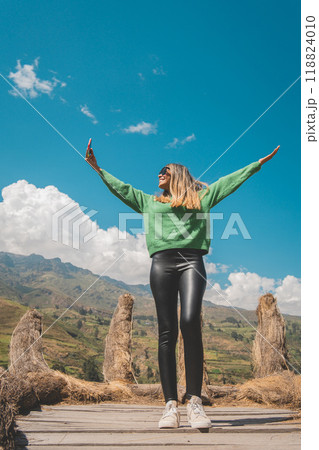 A woman in a green sweater is standing on a bridge, viewpoint in Canta, Lima, Peru. 118824010