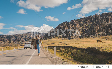 A woman is walking, hitchhiking on a road in Huayllay Stone Forest, Peru. 118824021