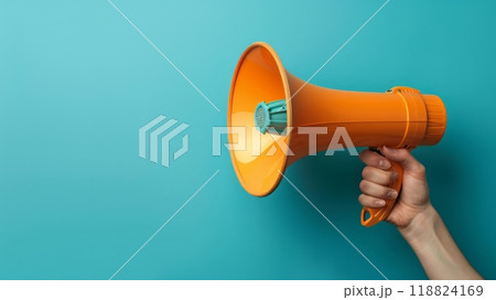 A person holding a megaphone in their hand against blue background  118824169