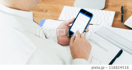 スマホを操作する作業服の男性 118824518