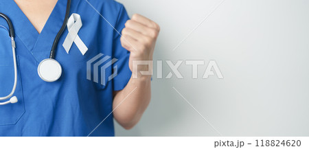 November Lung Cancer Awareness month and Stop Violence Against Women. Doctor with White ribbon in hospital. Healthcare and World Cancer day concept November Lung Cancer Awareness month and Stop Violence Against Women. Doctor with White ribbon in hospital. Healthcare and World Cancer day concept 118824620