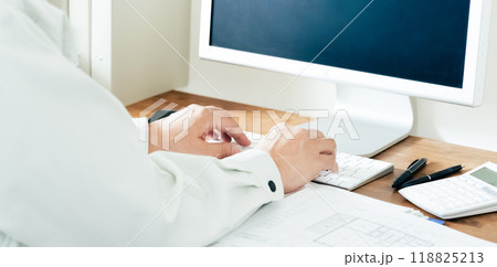 パソコン操作をする作業服の男性の手元 118825213