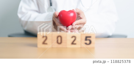 Happy New Year 2025 with doctor holding red heart shape on table. health care, Insurance, donation, Wellness and medical concepts 118825378