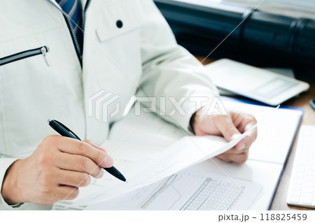 書類をチェックする作業服の男性 書類をチェックする作業服の男性 118825459