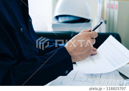 書類をチェックする作業服の男性 書類をチェックする作業服の男性 118825707