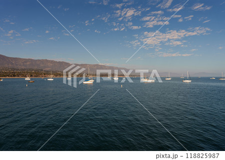 Boats float on water, with mountains beautifully visible behind 118825987