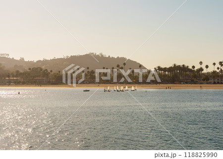 A body of water with a beach and mountains in the background A body of water with a beach and mountains in the background 118825990