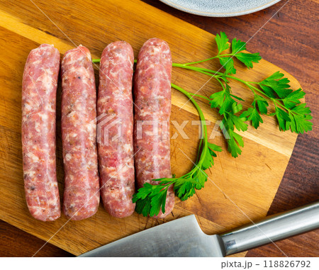 Delicious butifarra from minced meat on wooden surface, pork sausage with mushrooms Delicious butifarra from minced meat on wooden surface, pork sausage with mushrooms 118826792