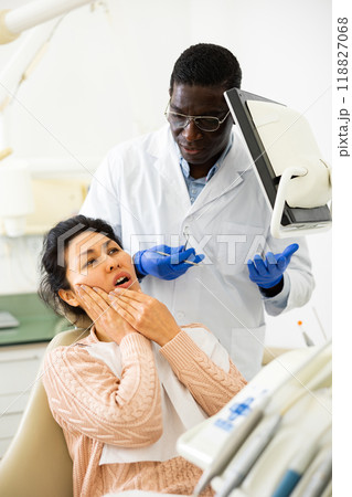 Asian woman with toothache sitting in chair at dentist appointment Asian woman with toothache sitting in chair at dentist appointment 118827068