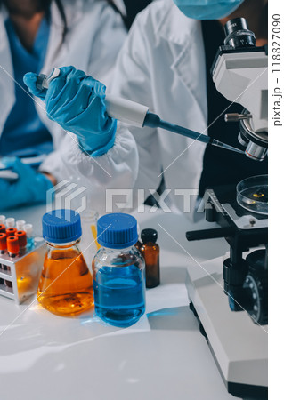 Scientist using microscope in laboratory. Close-up of a researcher's hands adjusting a modern microscope in a lab setting. Science concept Scientist using microscope in laboratory. Close-up of a researcher's hands adjusting a modern microscope in a lab setting. Science concept 118827090