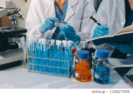 Scientist using microscope in laboratory. Close-up of a researcher's hands adjusting a modern microscope in a lab setting. Science concept Scientist using microscope in laboratory. Close-up of a researcher's hands adjusting a modern microscope in a lab setting. Science concept 118827098