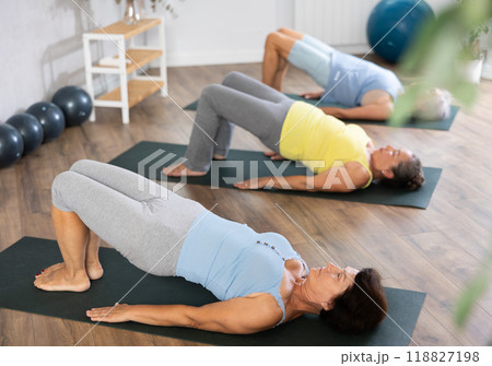 Group of elderly woman doing pilates on mat in studio 118827198