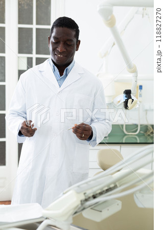 Portrait of a friendly african american dentist doctor in clinic Portrait of a friendly african american dentist doctor in clinic 118827270