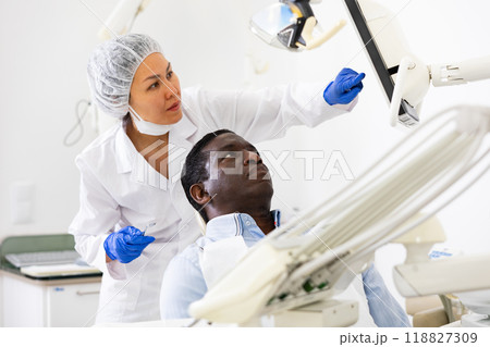 Doctor dentist shows the patient the result of dental x-ray Doctor dentist shows the patient the result of dental x-ray 118827309