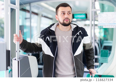 Portrait of male passenger in tram car on spring day 118827334