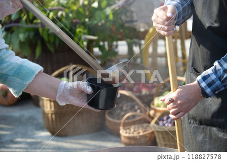 Serving food outdoors with baskets of vegetables in the background Serving food outdoors with baskets of vegetables in the background 118827578