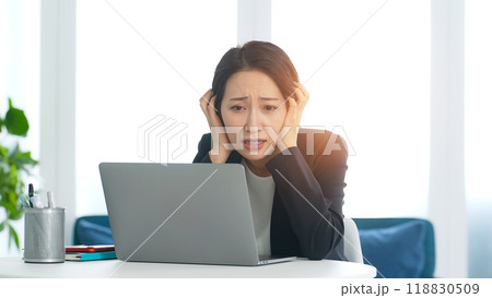 オフィスでノートパソコンを見て悩む女性ビジネスパーソン オフィスでノートパソコンを見て悩む女性ビジネスパーソン 118830509