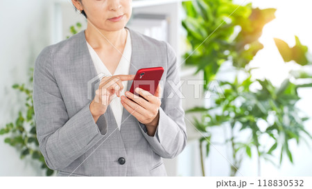 オフィスでスマホを使う女性ビジネスパーソン オフィスでスマホを使う女性ビジネスパーソン 118830532