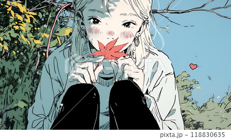 色づいた紅葉の葉を手に取る若い女性
