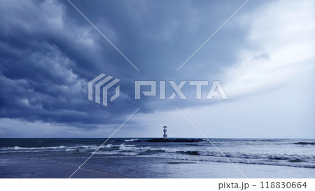 A solitary lighthouse stands in the ocean 118830664
