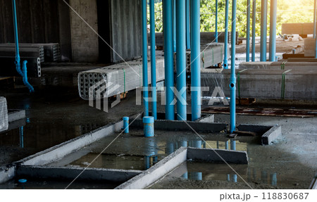 A large building currently under construction that has many blue pipes A large building currently under construction that has many blue pipes 118830687