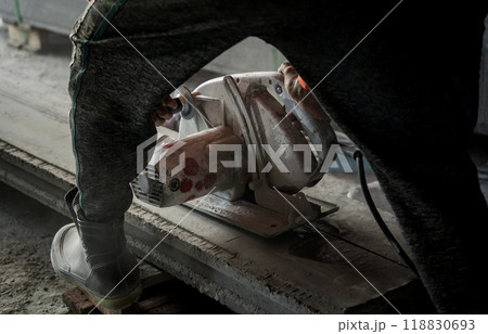 A builder using a circular saw to cut a large concrete piece A builder using a circular saw to cut a large concrete piece 118830693