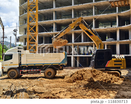 Excavator loads ground into a dump truck at a construction site 118830713